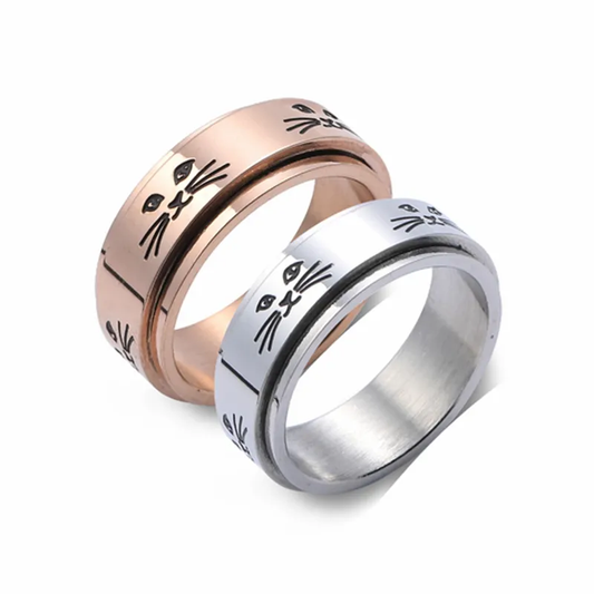 Two spinnable rings for your fingers. The top one is a rose gold and the bottom one is a silver. Both have eyes, mouths and whiskers to represent cat faces on them.