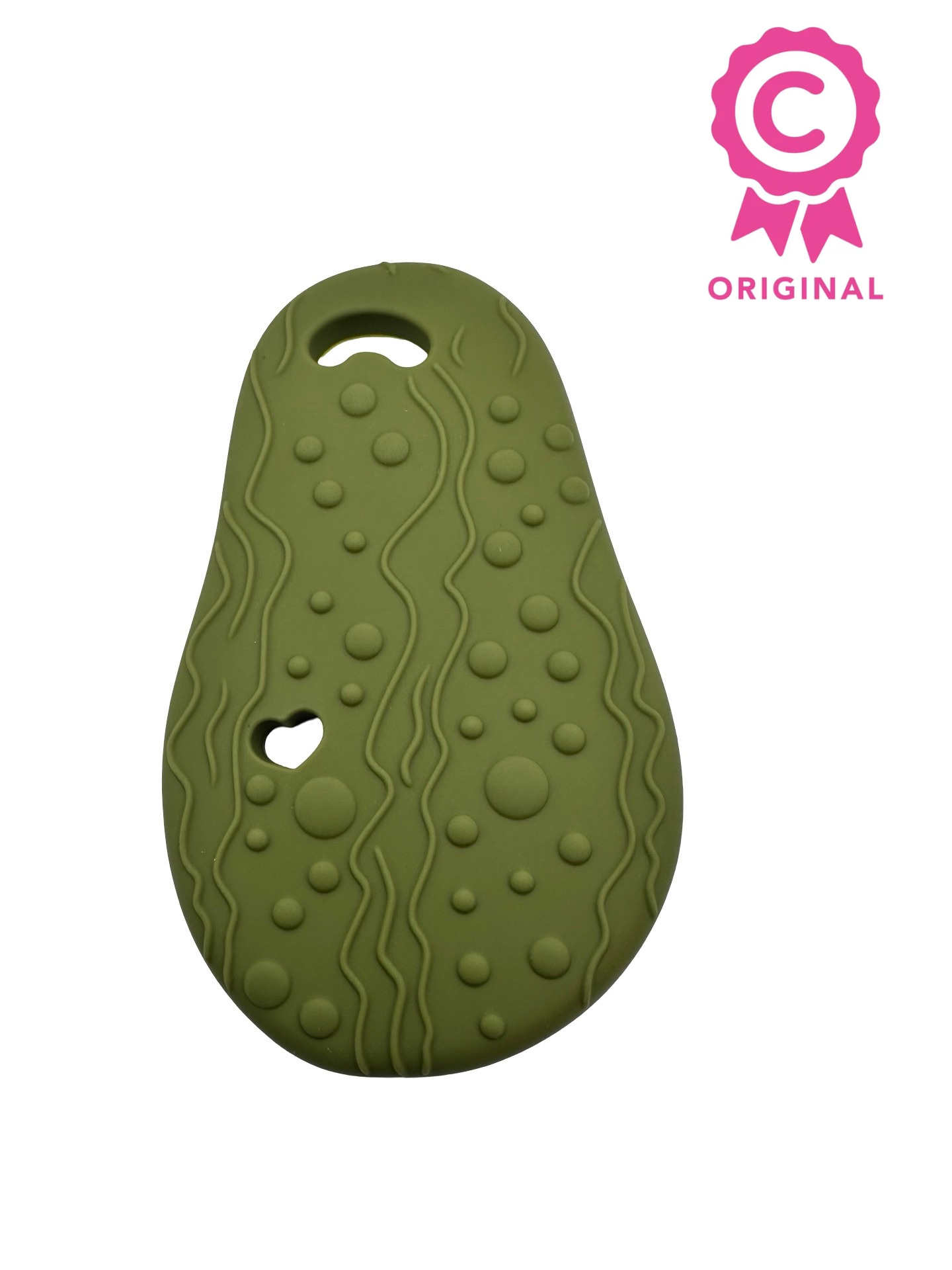 The back of an avocado chewable teether. There are several raised bumps for texture with a hole at the top for a necklace cord. There is a badge in the upper right that says “C” with the word “original” underneath.