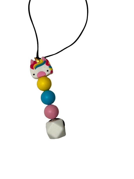 There is a unicorn bead on the top of these chewable beads. Underneath are three rounds beads in the following colours: yellow, blue and pink. There is a large white hexagon at the bottom.