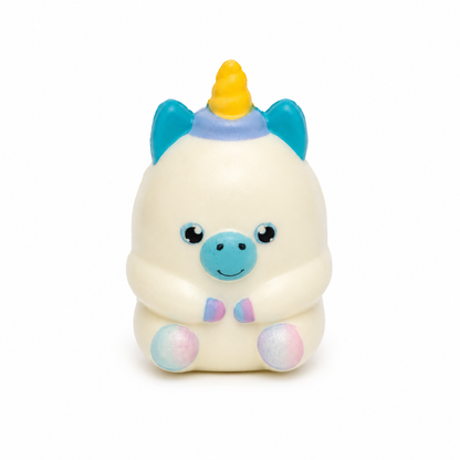 Small white-coloured unicorn squishy with a yellow horn, teal ears and muzzle, pastel hooves, and a tiny pastel bow tie, shown from the front against a white background.
