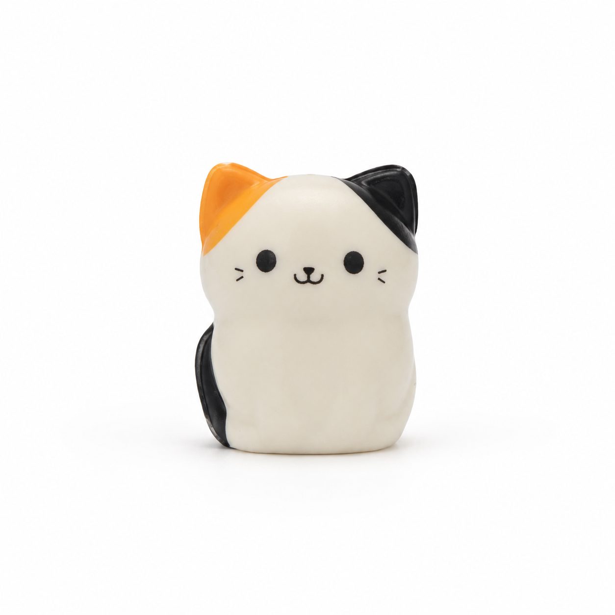 A small squish cat with a tri-color calico pattern, featuring a white-colored body, an orange ear, and a black ear, set against a plain white background.