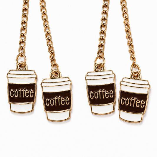 Close-up of four white takeaway coffee cup charms with dark brown sleeves, gold-tone outlines, and “coffee” lettering, hanging from gold-tone chains against a white background.