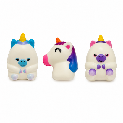 Three small white-coloured unicorn squishies displayed against a white background. The designs feature colourful horns, ears, faces, hooves, and manes in blue, pink, purple, and yellow.