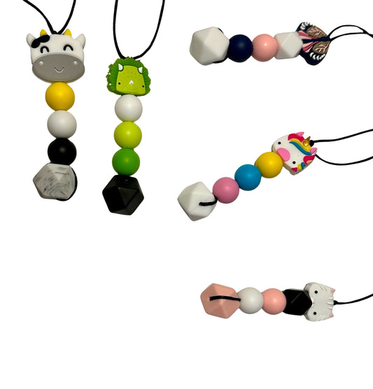 There are five various bead pattern chew necklaces. There is a cow, a green dinosaur, a blue moth, a unicorn and a white cat. 