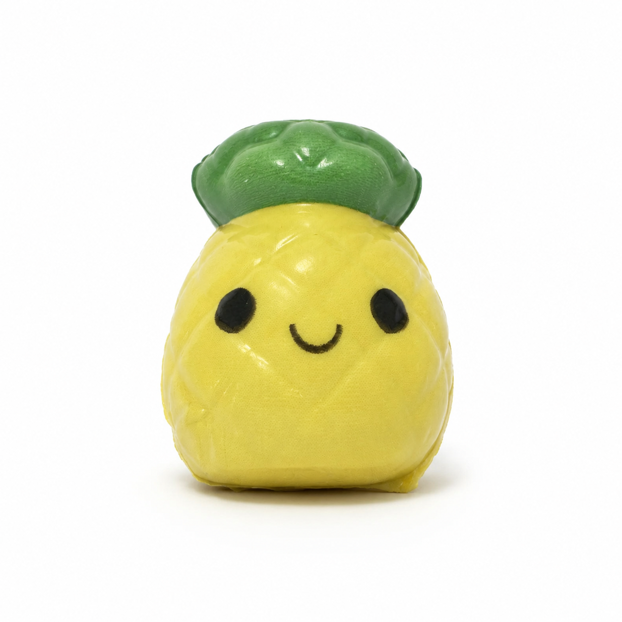 Small yellow pineapple squishy with a dark green leafy top, black oval eyes, and a simple smiling face, shown upright against a white background.