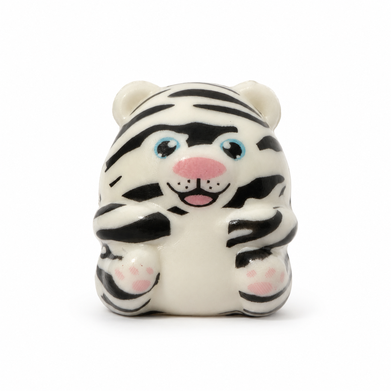 A small white squish tiger with black stripes, blue eyes, and a pink nose and paws, sitting against a plain white background.